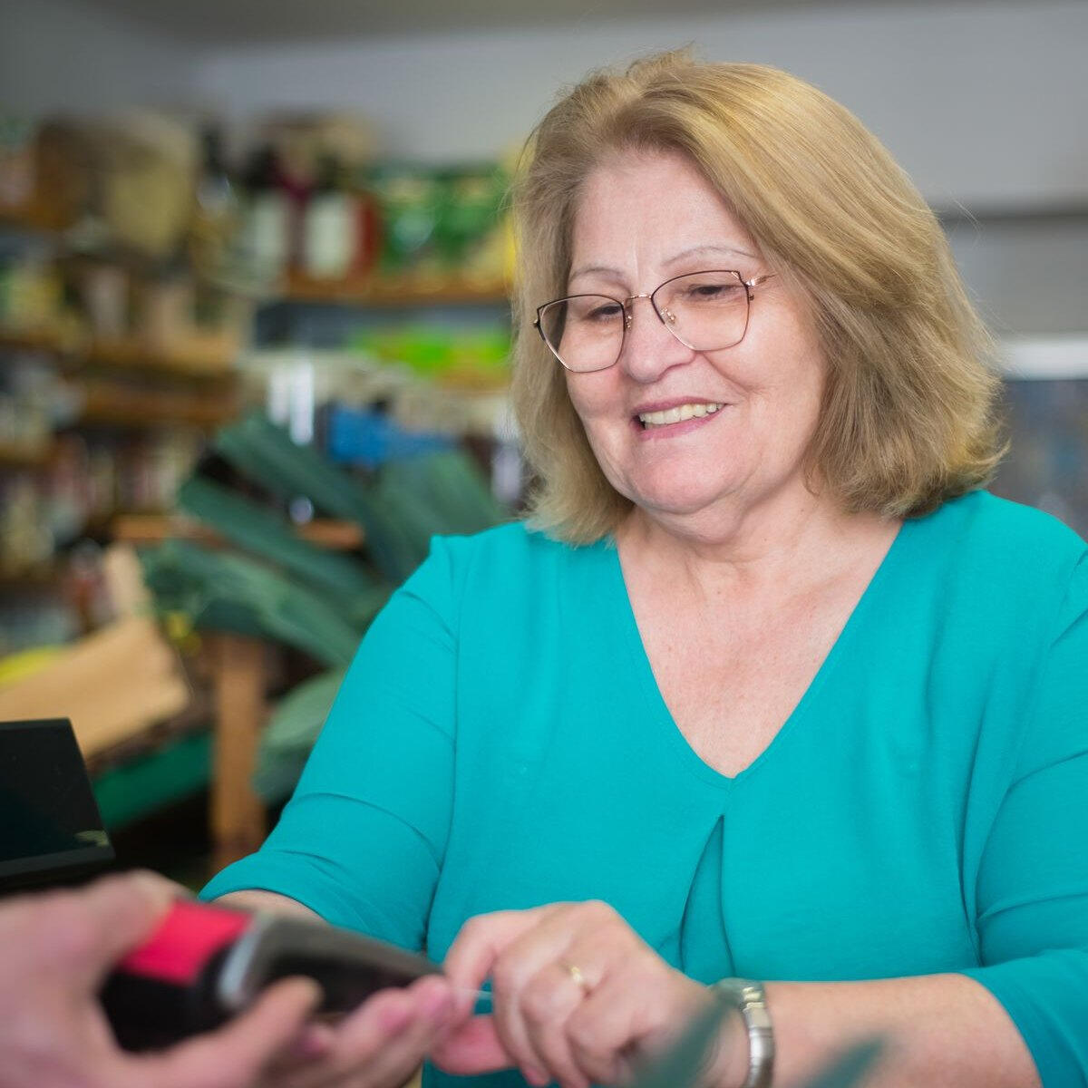 Smiling older woman working at a store checkout